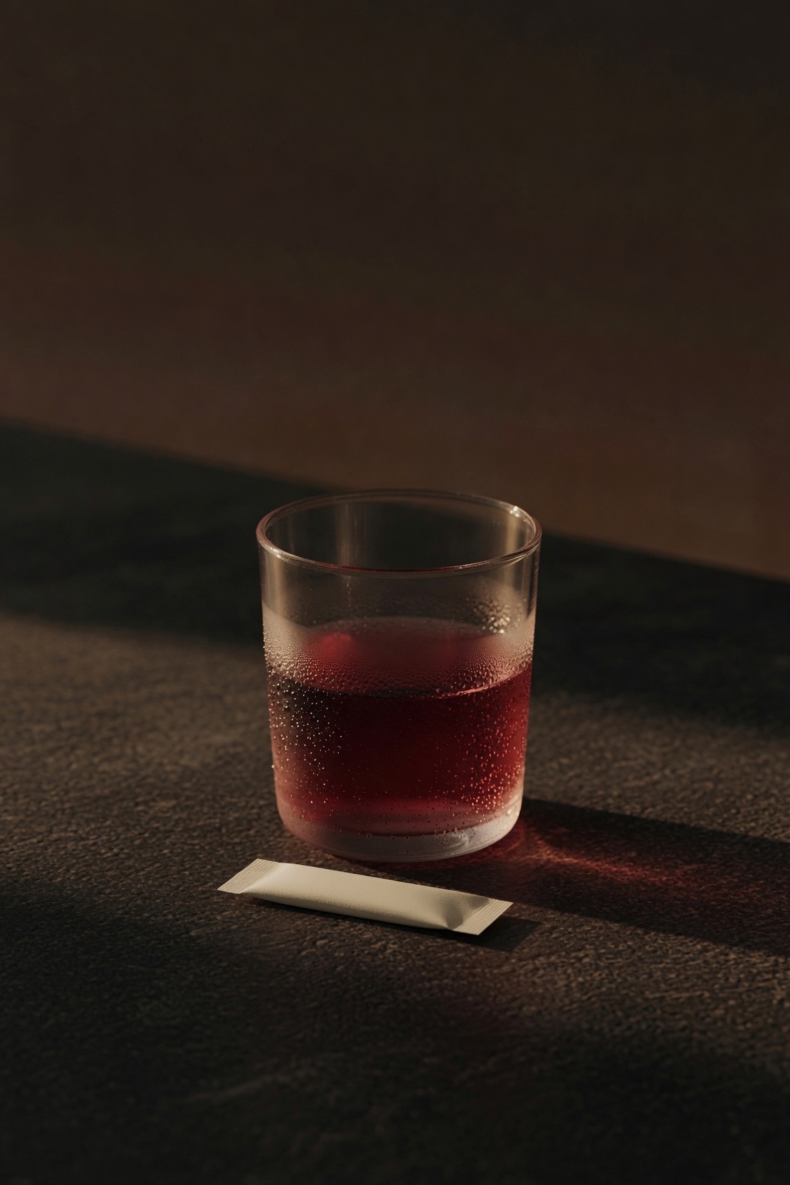 Verre rose profond et stick, crépuscule